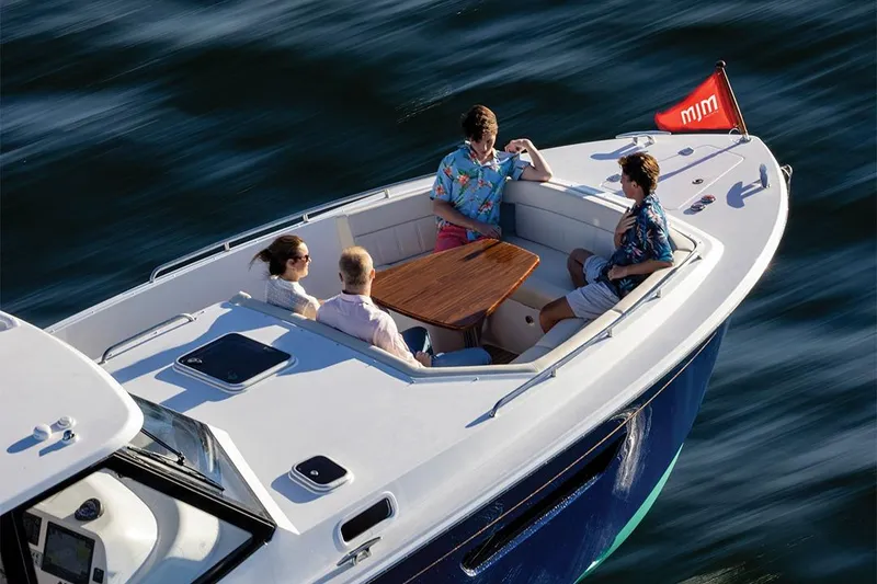 Slide: The Image of Four people relaxing on a 2025 MJM 4 boat. - 15