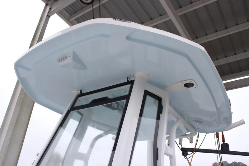 Slide: The Image of 2026 Tidewater 2500 Carolina Bay boat's T-top and console under a canopy. - 13