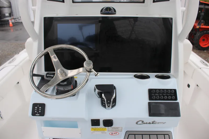 Slide: The Image of 2026 Tidewater 2500 Carolina Bay boat console with steering wheel and control panel. - 14