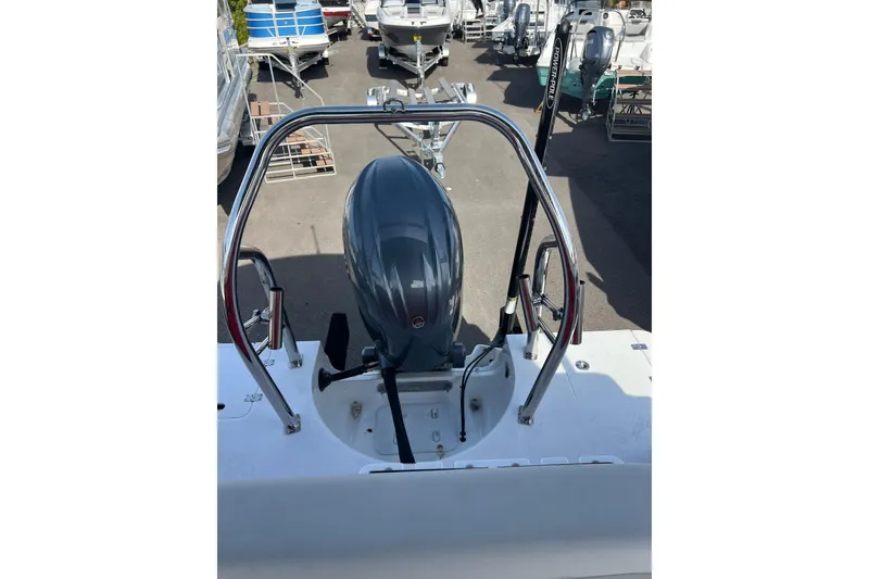 Slide: The Image of 2026 Hurricane FunDeck 2260 REF OB boat engine and railing in a marina. - 15