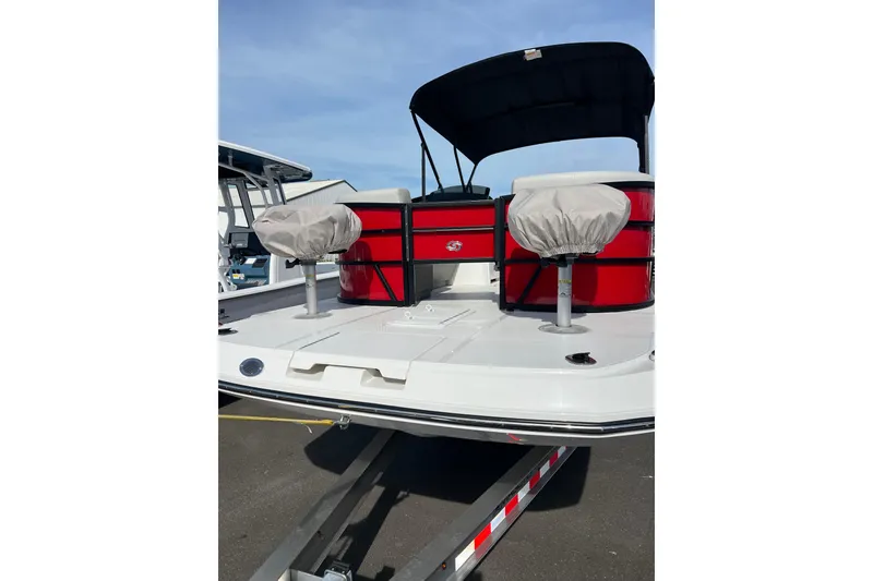 Slide: The Image of 2026 Hurricane FunDeck 2260 REF OB boat with red seating and covered chairs. - 2