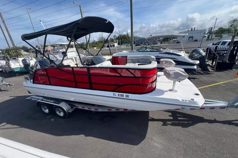 Slide: The Image of 2026 Hurricane FunDeck 2260 REF OB boat with red and white design on a trailer. - 6