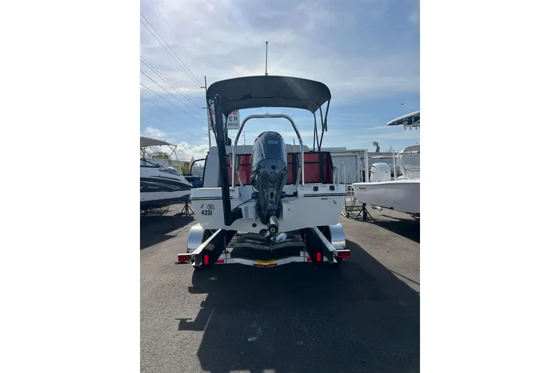 Slide: The Image of 2026 Hurricane FunDeck 2260 REF OB boat, rear view with outboard motor, parked outdoors. - 7