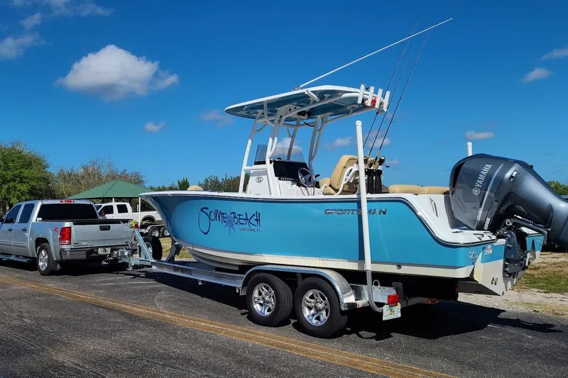 Slide: The Image of 2019 Sportsman Heritage 241 Center Console boat with canopy, parked in a residential driveway. - 18