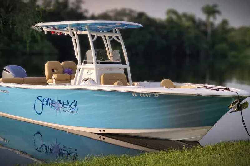 Slide: The Image of 2019 Sportsman Heritage 241 Center Console boat docked on calm water. - 2