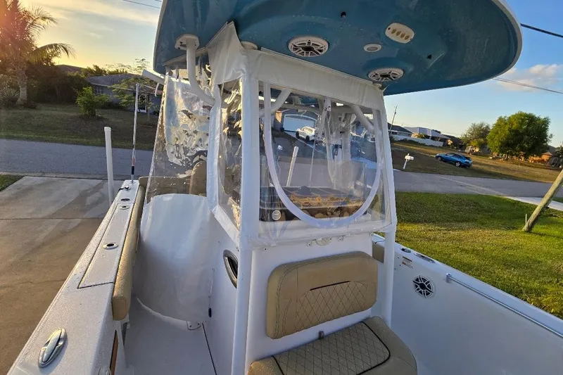 Slide: The Image of 2019 Sportsman Heritage 241 Center Console boat with clear enclosure, parked in a driveway. - 22