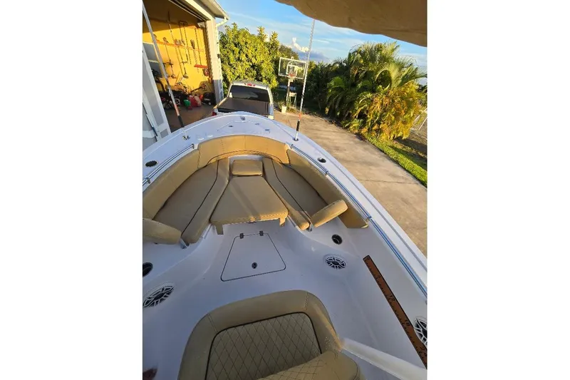 Slide: The Image of 2019 Sportsman Heritage 241 Center Console boat with tan seating, parked in driveway. - 23