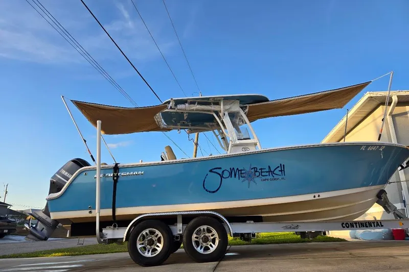 Slide: The Image of 2019 Sportsman Heritage 241 Center Console boat on trailer, blue hull, outdoor setting. - 24