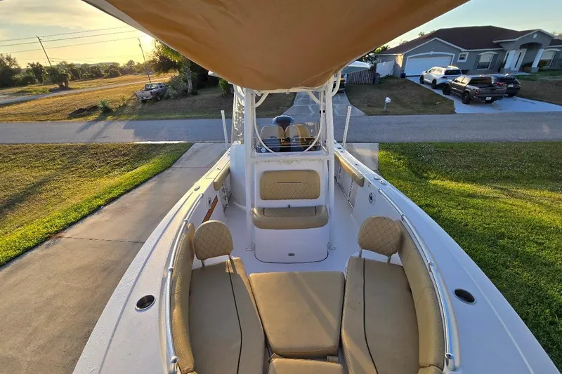 Slide: The Image of 2019 Sportsman Heritage 241 Center Console boat with tan seating, parked in a driveway. - 26