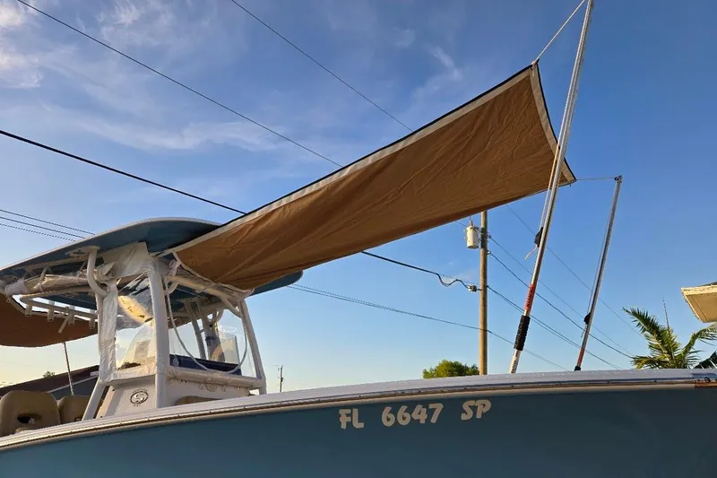Slide: The Image of 2019 Sportsman Heritage 241 Center Console boat with canopy, under clear blue sky. - 27