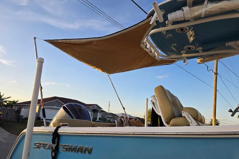 Slide: The Image of 2019 Sportsman Heritage 241 Center Console boat with sunshade, parked in residential area. - 28