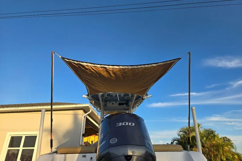 Slide: The Image of 2019 Sportsman Heritage 241 Center Console with canopy, parked outdoors under blue sky. - 29