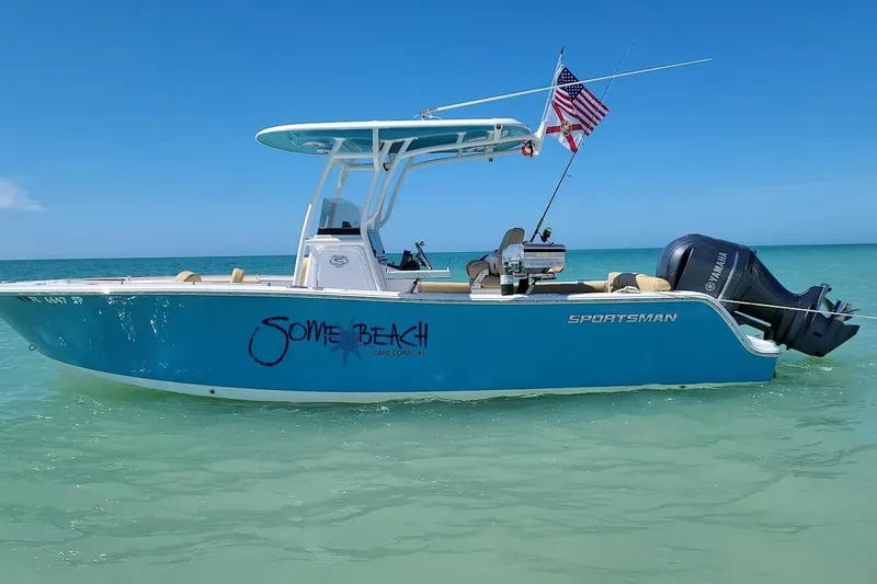 Slide: The Image of 2019 Sportsman Heritage 241 Center Console boat on calm water, lush greenery background. - 4