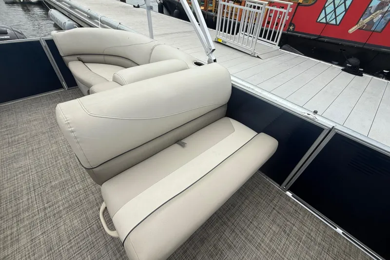 Slide: The Image of 2023 Cypress Cay Seabreeze 232 boat interior with beige seating and dock view. - 10