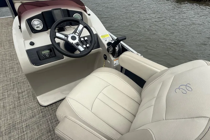 Slide: The Image of 2023 Cypress Cay Seabreeze 232 boat helm with steering wheel and beige captain's chair. - 7