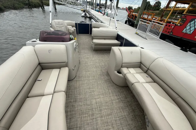 Slide: The Image of 2023 Cypress Cay Seabreeze 232 pontoon boat with spacious seating, docked by the water. - 8