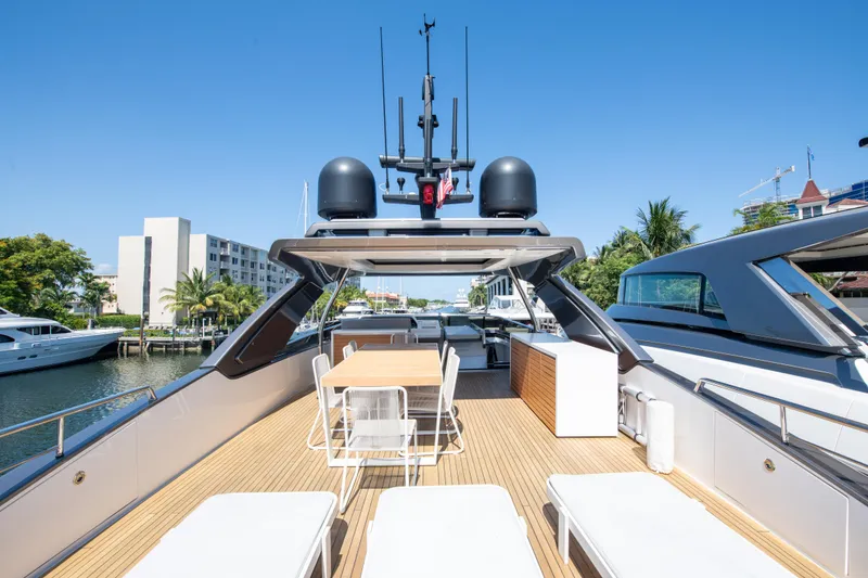 Slide: The Image of Sanlorenzo SL78 2022 yacht deck with seating and dining area, docked in a marina. - 12