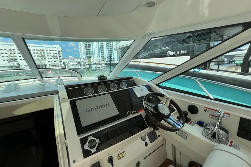 Slide: The Image of 2010 Sea Ray 450 Sundancer helm with Garmin navigation, docked in a marina. - 11