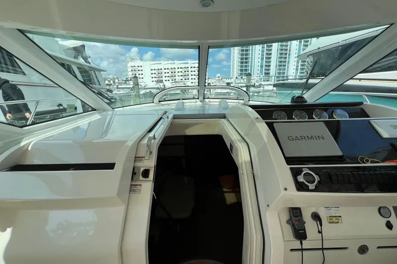 Slide: The Image of 2010 Sea Ray 450 Sundancer yacht cockpit with Garmin navigation, docked in a marina. - 14