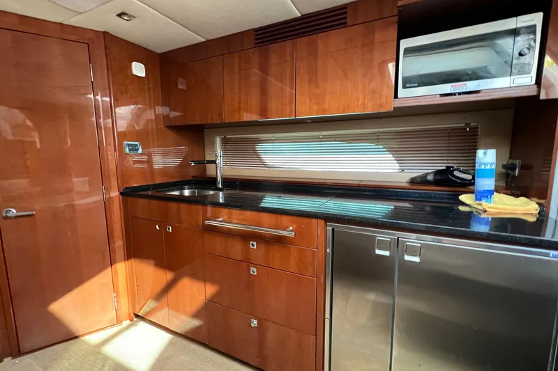 Slide: The Image of Luxurious 2010 Sea Ray 450 Sundancer yacht kitchen with wood cabinetry and modern appliances. - 17