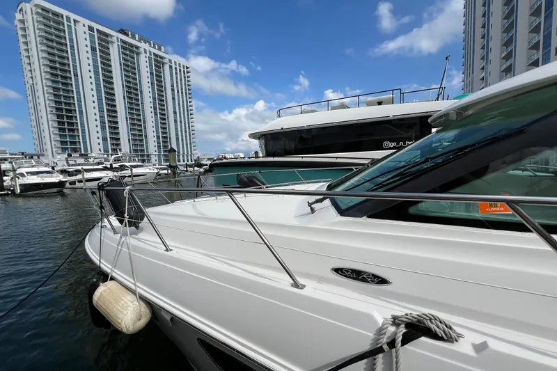 Slide: The Image of 2010 Sea Ray 450 Sundancer yacht docked in marina, with high-rise buildings in background. - 2