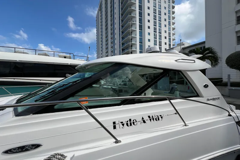 Slide: The Image of 2010 Sea Ray 450 Sundancer yacht docked near modern high-rise buildings. - 3