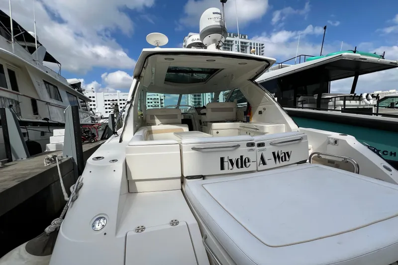 Slide: The Image of 2010 Sea Ray 450 Sundancer yacht docked, featuring spacious deck and modern design. - 4