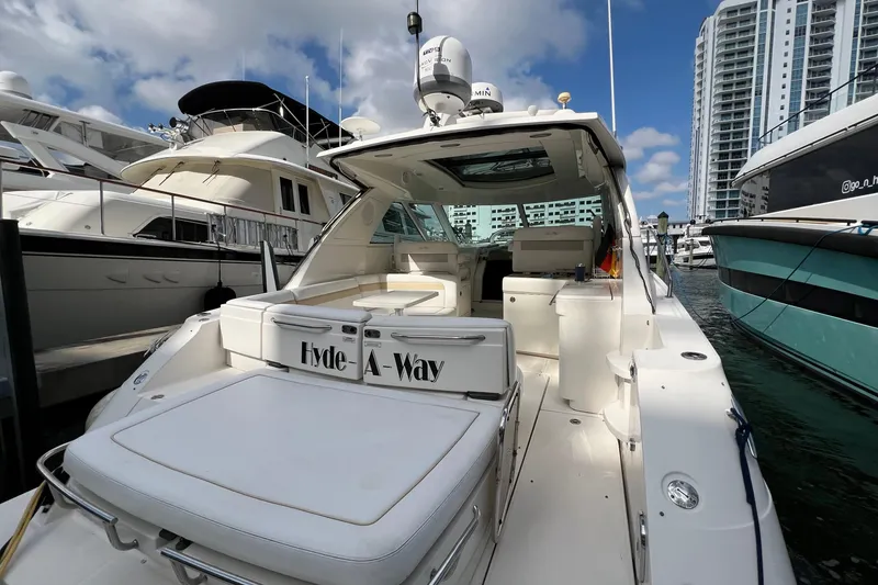 Slide: The Image of 2010 Sea Ray 450 Sundancer yacht docked at marina, surrounded by other boats and high-rise buildings. - 5