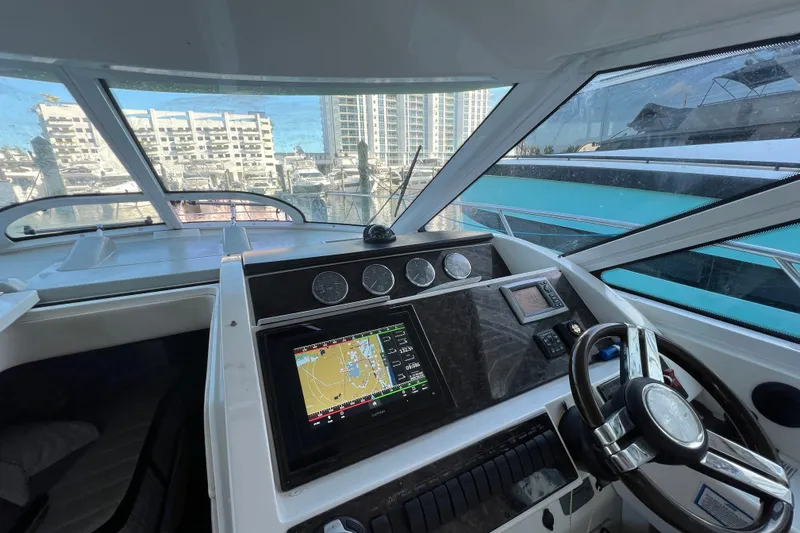 Slide: The Image of Helm of 2010 Sea Ray 450 Sundancer with navigation display and cityscape view. - 6