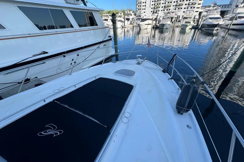 Slide: The Image of 2010 Sea Ray 450 Sundancer yacht docked in marina, surrounded by other boats. - 7