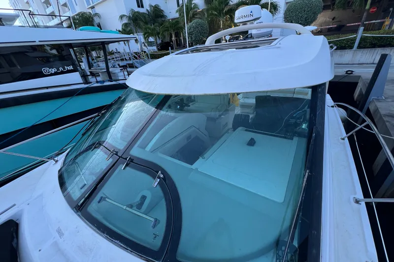 Slide: The Image of 2010 Sea Ray 450 Sundancer yacht docked, featuring sleek design and modern navigation equipment. - 9