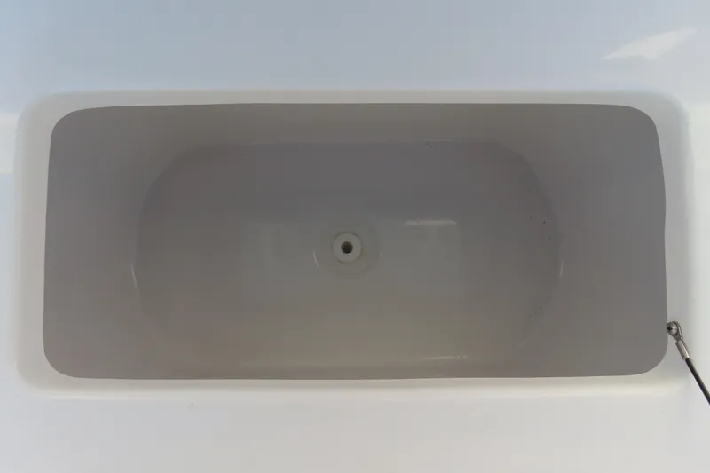 Slide: The Image of Livewell compartment in 2023 Sea Hunt Ultra 234 boat, featuring a clean, white interior. - 18