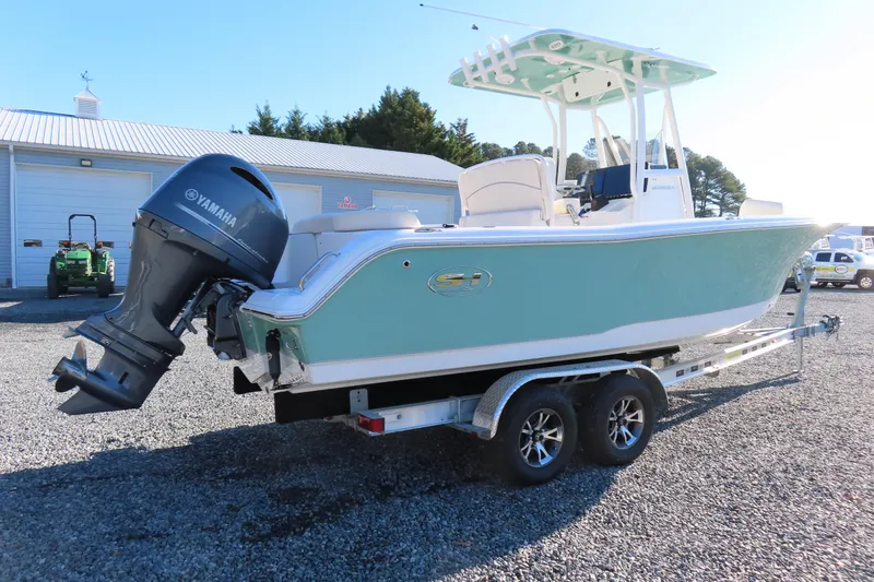 Slide: The Image of 2023 Sea Hunt Ultra 234 boat on trailer with Yamaha outboard motor, parked outdoors. - 2