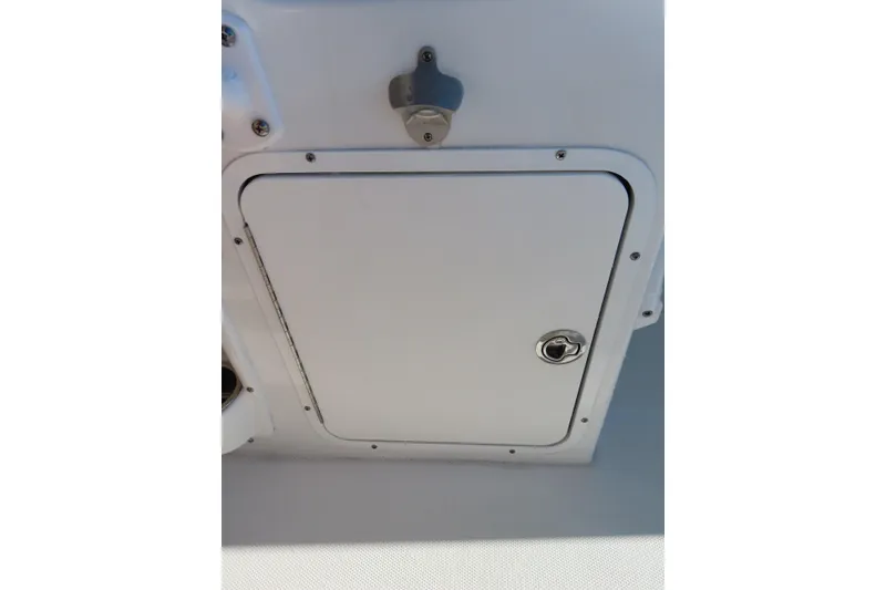Slide: The Image of 2023 Sea Hunt Ultra 234 boat storage compartment with secure latch and sleek design. - 33