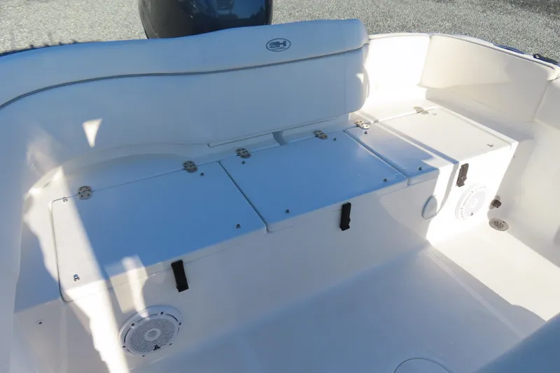 Slide: The Image of 2023 Sea Hunt Ultra 234 boat interior with white seating and storage compartments. - 38