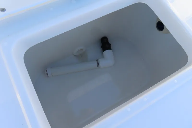 Slide: The Image of Livewell compartment in 2023 Sea Hunt Ultra 234 boat, featuring white interior and plumbing. - 41
