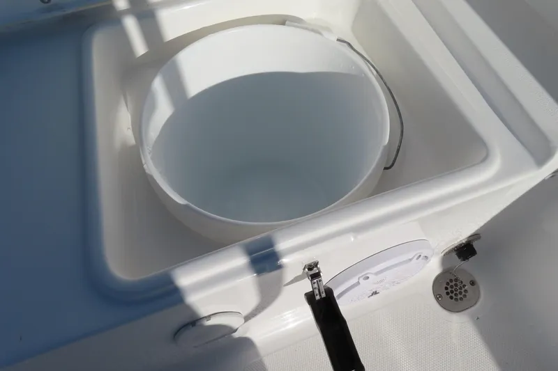 Slide: The Image of 2023 Sea Hunt Ultra 234 boat with built-in storage compartment and white bucket. - 42