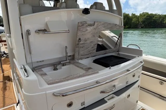Slide: The Image of 2020 Solace 345 CC boat with outdoor kitchen, sink, and storage by the water. - 11