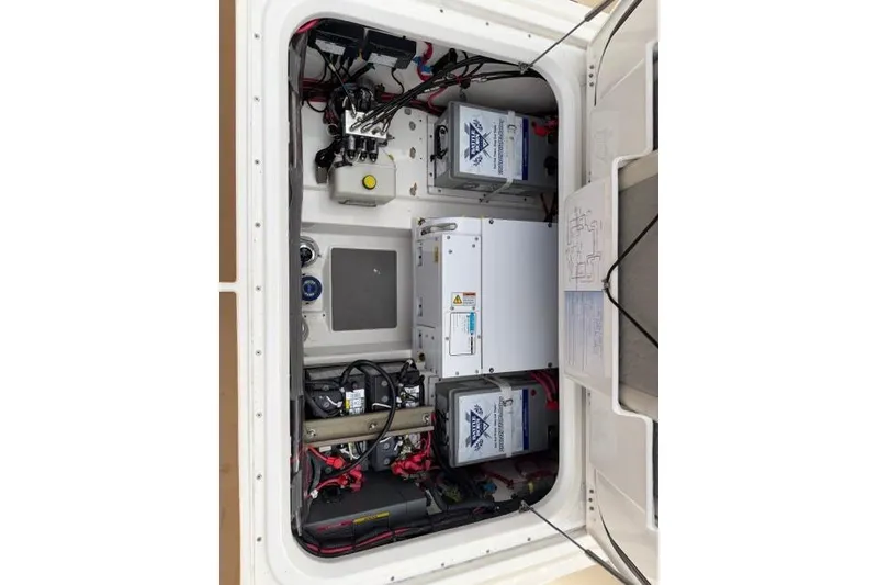 Slide: The Image of Electrical compartment of a 2020 Solace 345 CC boat, showcasing batteries and wiring. - 13