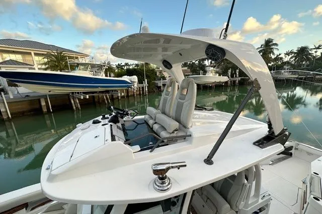 Slide: The Image of 2020 Solace 345 CC boat with sleek design, docked near waterfront homes. - 17