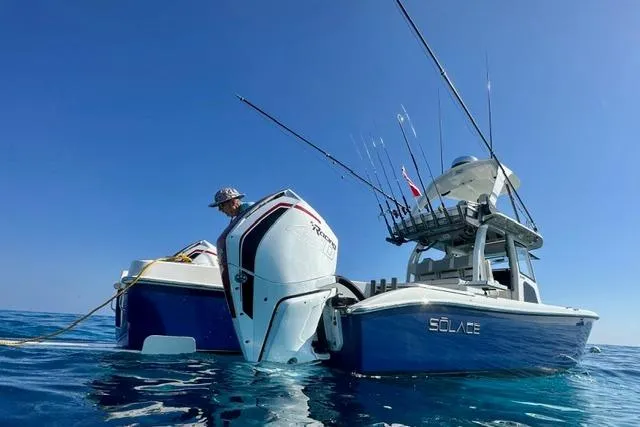 Slide: The Image of 2020 Solace 345 CC boat on water, equipped with fishing rods and powerful engines. - 3