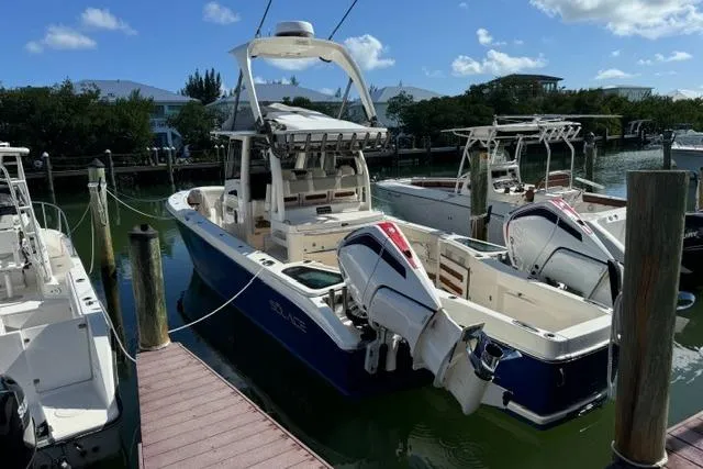 Slide: The Image of 2020 Solace 345 CC boat docked, featuring dual outboard engines and sleek design. - 6
