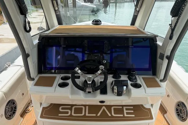Slide: The Image of 2020 Solace 345 CC boat dashboard with steering wheel and control panel. - 8