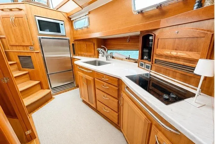 Slide: The Image of Luxurious 2013 Sabre 48 Salon Express yacht kitchen with wood cabinetry and modern appliances. - 11