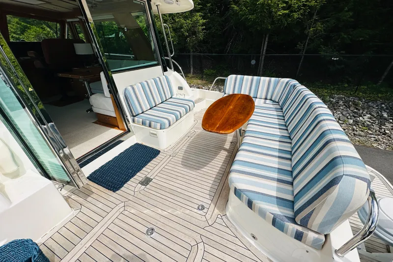 Slide: The Image of 2013 Sabre 48 Salon Express yacht with striped seating and wooden table on deck. - 14