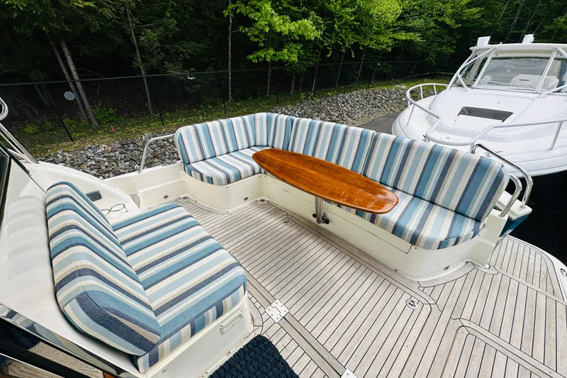 Slide: The Image of 2013 Sabre 48 Salon Express yacht with striped seating and wooden table on deck. - 15