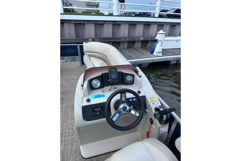 Slide: The Image of 2023 Cypress Cay Seabreeze 232 boat dashboard with steering wheel and controls at dock. - 5