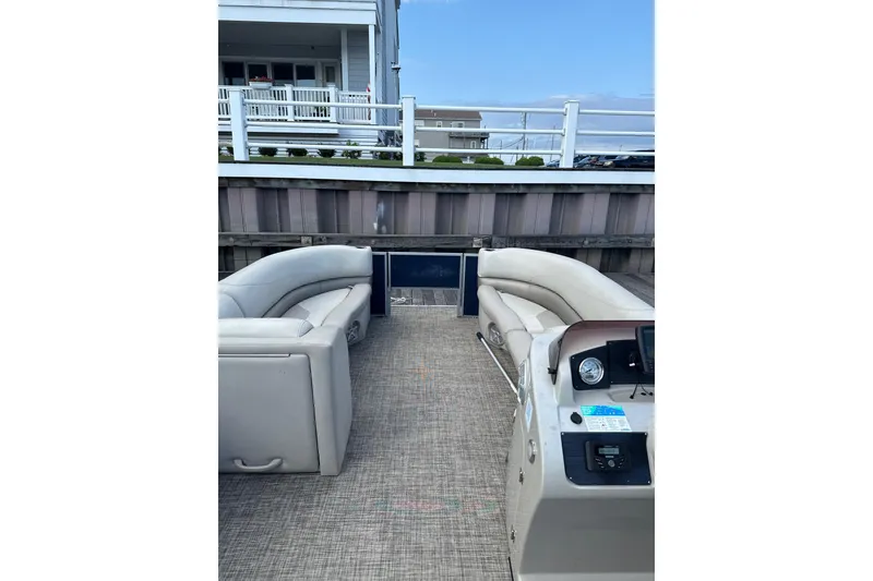 Slide: The Image of 2023 Cypress Cay Seabreeze 232 pontoon boat interior with plush seating and control panel. - 6