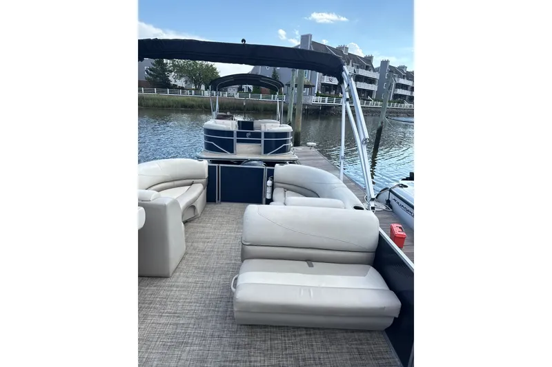 Slide: The Image of 2023 Cypress Cay Seabreeze 232 pontoon boat with spacious seating, docked by the water. - 7