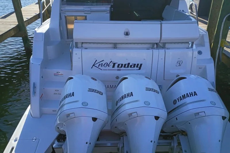 Slide: The Image of 2020 Regal 38 XO boat with triple Yamaha 300 engines, docked at a marina. - 10